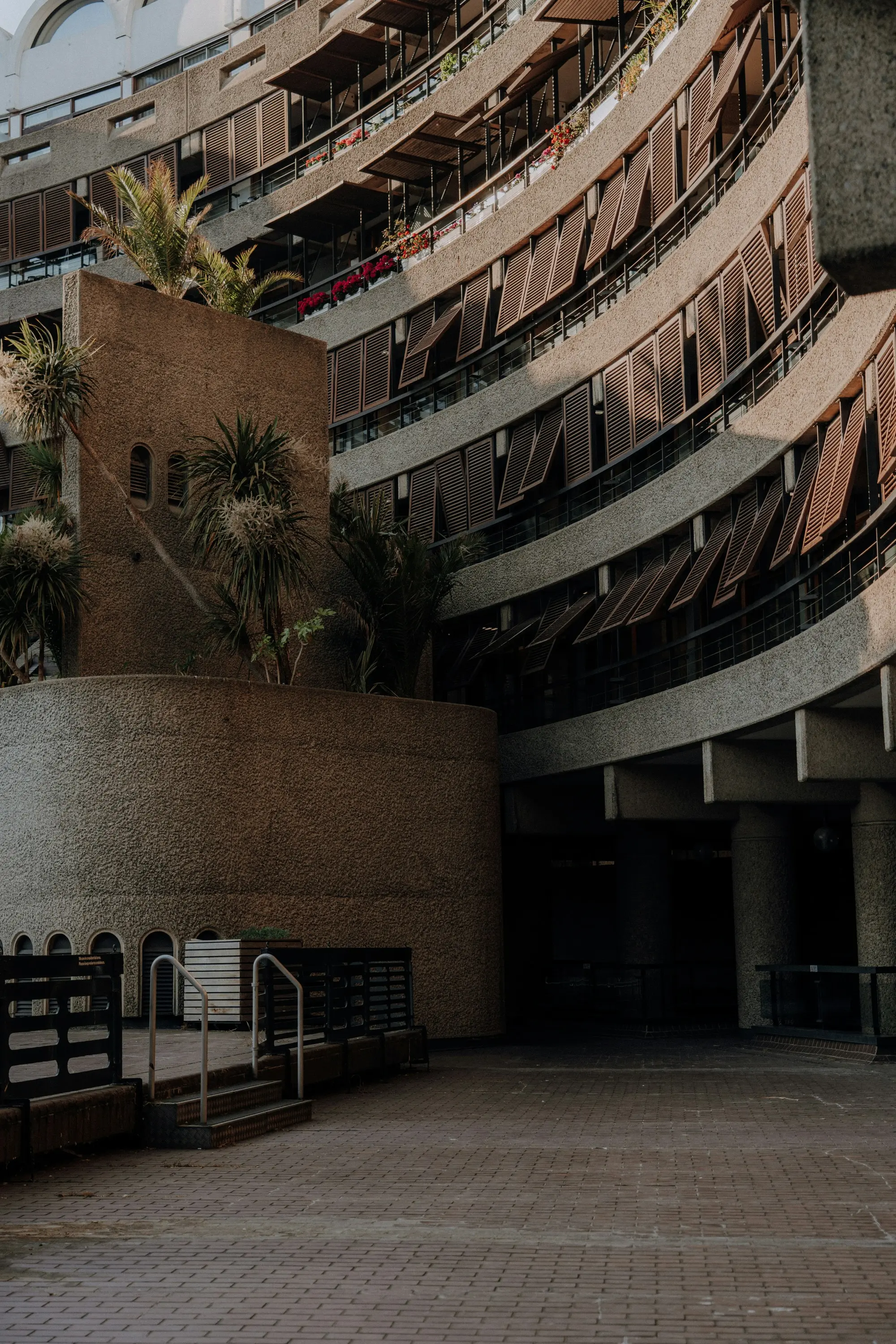 Verda residential design house: a curved terraced courtyard, planting spilling over concrete balconies
